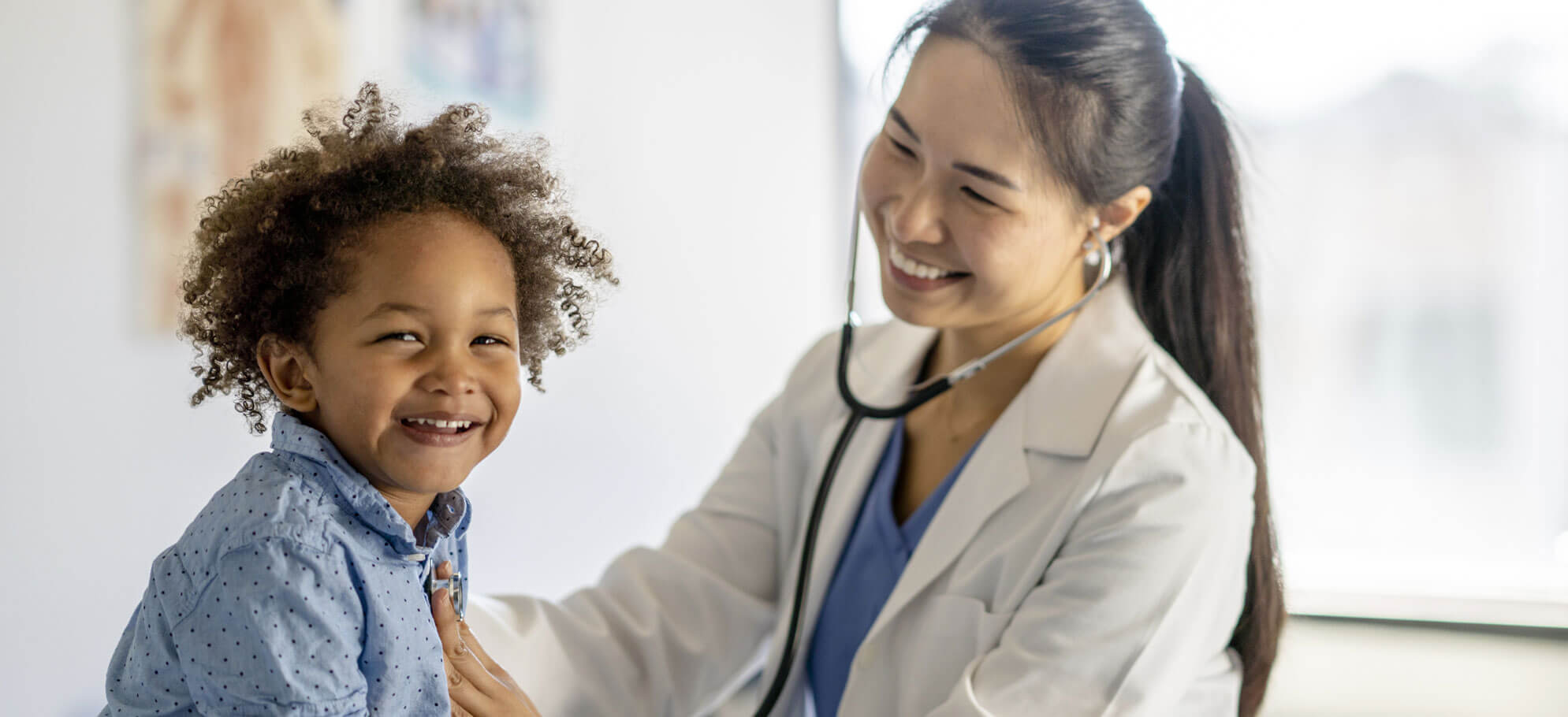 pediatric dermatologist smiling next to little girl